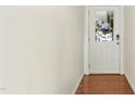 Hallway with white walls, hardwood floor, and a white door with glass insert at 219 Broadgait Brae Rd, Cary, NC 27519