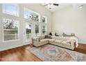 Bright living room features high ceilings, large windows and a comfortable seating area with hardwood floors at 219 Broadgait Brae Rd, Cary, NC 27519