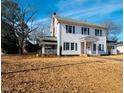 Two story white house with classic design, front yard, and mature trees at 301 N Ellis Ave, Dunn, NC 28334