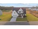 Two-story home boasts a modern white exterior, complemented by a well-manicured lawn and a paved driveway at 66 Tennyson Dr, Garner, NC 27529