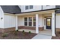 Front porch with white columns, brick accents and meticulous landscaping, showcasing home's curb appeal at 66 Tennyson Dr, Garner, NC 27529