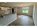 Open dining area adjacent to the kitchen featuring a modern chandelier and natural light at 69 N Movado Trl, Kenly, NC 27542