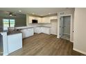 Spacious kitchen with white cabinets, granite countertops, stainless steel appliances, and wood flooring at 69 N Movado Trl, Kenly, NC 27542