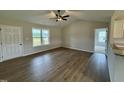 Bright living room with wood floors, large window, ceiling fan, and neutral walls at 69 N Movado Trl, Kenly, NC 27542