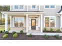 Front entrance with a dark door, white columns, and brick accents at 88 Tennyson Dr, Garner, NC 27529