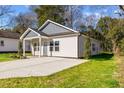 Newly built home with gray accents, a paved driveway, and a well-manicured lawn at 1007 N King Ave, Dunn, NC 28334