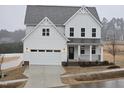 Two-story white farmhouse with a black front door and attached two-car garage at 1013 Prominence Dr., Homesite 22, Durham, NC 27712