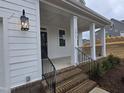 Brick steps and porch with black metal railing lead to the front entrance at 1013 Prominence Dr., Homesite 22, Durham, NC 27712