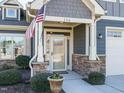 Front entry with stone accents, glass door, and American flag at 116 Telluride Trl, Garner, NC 27529