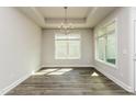 A bright dining room with large windows, wood-look tile floors and modern chandelier at 134 Oban Dr, Homesite 133, Sanford, NC 27330