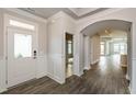 A welcoming entryway with white wainscoting, an arched doorway and wood-look tile floors at 134 Oban Dr, Homesite 133, Sanford, NC 27330
