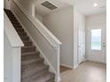 Modern staircase with neutral carpeting and wooden handrail at 207 Shelfit Trl, Oxford, NC 27565
