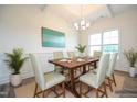 Bright dining room with wainscoting, wood table, chandelier, and large window at 223 Johnson Ridge Way, Four Oaks, NC 27524
