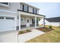 Welcoming front porch with stone accents and professionally landscaped flower beds at 223 Johnson Ridge Way, Four Oaks, NC 27524