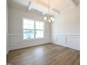 Dining room with hardwood flooring, wainscoting, coffered ceilings and large windows allowing natural light at 236 Johnson Ridge Way, Four Oaks, NC 27524