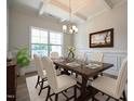 Elegant dining room featuring coffered ceilings, wainscoting, and a stylish chandelier at 236 Johnson Ridge Way, Four Oaks, NC 27524