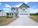 Charming two-story home with a two-car garage, concrete driveway, landscaped front yard, and covered front porch at 236 Johnson Ridge Way, Four Oaks, NC 27524