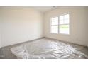 Bright, empty bedroom showcasing ample natural light through a large window at 247 Johnson Ridge Way, Four Oaks, NC 27524
