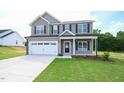 Charming two-story home with a covered front porch, two-car garage, and a well-manicured front lawn at 247 Johnson Ridge Way, Four Oaks, NC 27524