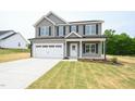 Charming two-story home featuring a gray exterior, two-car garage, and well-manicured lawn at 247 Johnson Ridge Way, Four Oaks, NC 27524
