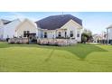 Well-maintained backyard with a spacious lawn, stone patio area, and privacy fencing at 347 Country Mill Way, Fuquay Varina, NC 27526