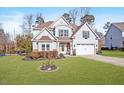 Beautiful two-story home showcasing a well-kept lawn, complemented by mature trees and manicured landscaping at 347 Country Mill Way, Fuquay Varina, NC 27526