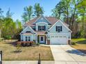 Lovely two-story home boasts a well-maintained lawn, a two-car garage, and mature trees at 347 Country Mill Way, Fuquay Varina, NC 27526