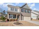 Two-story home with gray and brown brick exterior, landscaping, and a two-car garage at 370 Hickory Run Ln, Franklinton, NC 27525