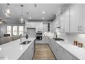 Modern kitchen with white cabinets, quartz countertops, and stainless steel appliances at 4809 Bristol Meadow Dr, Raleigh, NC 27603