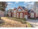 Brick home with a long driveway and lush landscaping at 58 Alecia Ct, Clayton, NC 27527