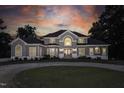 Stunning two-story home with a circular driveway at dusk at 5891 Baker Ln, Rocky Mount, NC 27803