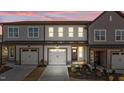 Charming townhouse featuring a two-car garage, well-maintained landscaping, and neutral color scheme at twilight at 610 Marshskip Way, Rolesville, NC 27587
