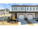 Stylish townhome facade with two-car garage, gray siding, and well-maintained front yard landscaping at 612 Marshskip Way, Rolesville, NC 27587