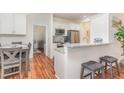 Modern kitchen with stainless steel appliances, white cabinetry, and granite countertops with bar stool seating at 620 Rollins Mill Rd, Holly Springs, NC 27540