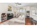 Cozy living room featuring a comfortable sofa, piano, ceiling fan, and plenty of natural light at 620 Rollins Mill Rd, Holly Springs, NC 27540