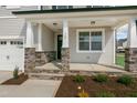 Covered front porch with stone columns and a charming front door at 82 Gin Branch Rd, Wendell, NC 27591