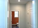 Hallway leading to a powder room featuring an orange accent wall and modern fixtures at 9164 Dupree Meadow Dr # 14, Angier, NC 27501