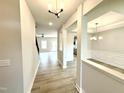 Inviting hallway with wood flooring, leading to living and dining areas featuring modern light fixtures at 111 Southern Estates Dr, Sanford, NC 27330
