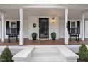 Inviting front porch with rocking chairs, planters, and a welcome mat at the front door at 210 W Oak Ave, Wake Forest, NC 27587