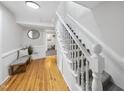 Bright hallway with hardwood floors, a staircase, and a bench with accent pillows at 210 W Oak Ave, Wake Forest, NC 27587