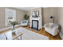 Cozy living room featuring a decorative fireplace, hardwood floors, and comfortable seating at 210 W Oak Ave, Wake Forest, NC 27587