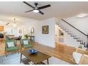 Bright, open-concept living room featuring hardwood floors, modern furnishings, and seamless flow to dining and kitchen at 211 Long Ave, Graham, NC 27253
