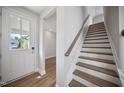 Welcoming entryway with hardwood floors, a staircase, and a front door with glass panels at 212 War Admiral Dr, Clayton, NC 27520