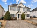 Two-story townhome with light beige siding, gray shutters, and a shared driveway at 2321 Turtle Point Dr, Raleigh, NC 27604