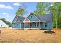 Attractive two-story home displays a blue exterior, complemented by a manicured yard and a partially-visible structure at 260 Ellington Rd, Graham, NC 27253