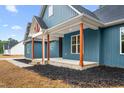 Blue house with inviting front porch supported by columns on a home with landscaped front yard at 260 Ellington Rd, Graham, NC 27253