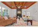 Bright living room boasts wood-paneled ceilings, a modern fireplace, and neutral-toned furniture with orange accents at 260 Ellington Rd, Graham, NC 27253