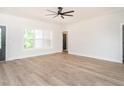 Spacious living room with wood-look flooring, white walls, and a ceiling fan at 260 Ellington Rd, Graham, NC 27253