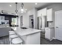 White kitchen features stainless steel appliances and an island with seating at 299 Broomside Ave, Raleigh, NC 27603