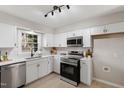 Modern kitchen featuring stainless steel appliances, white cabinets, and quartz countertops at 3 Patriot Cir, Durham, NC 27704